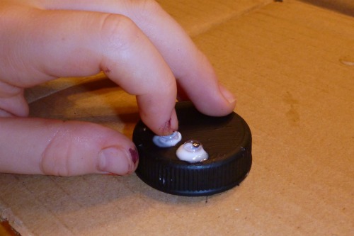 child gluing googly eyes
