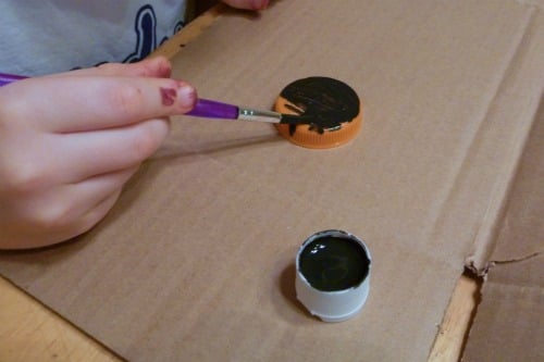 child painting bottle cap