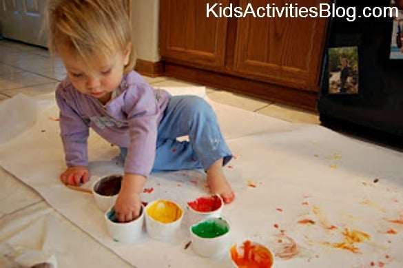 girl fingerpainting on floor