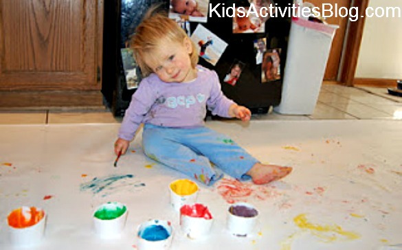 little girl painting on floor