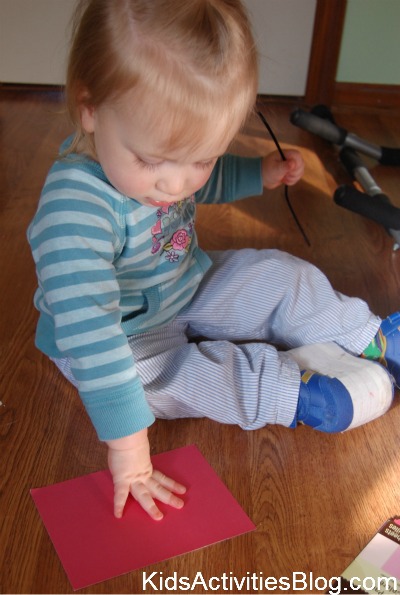 little girl with hand on red paper