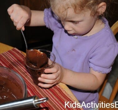 little girl making chocolate pudding