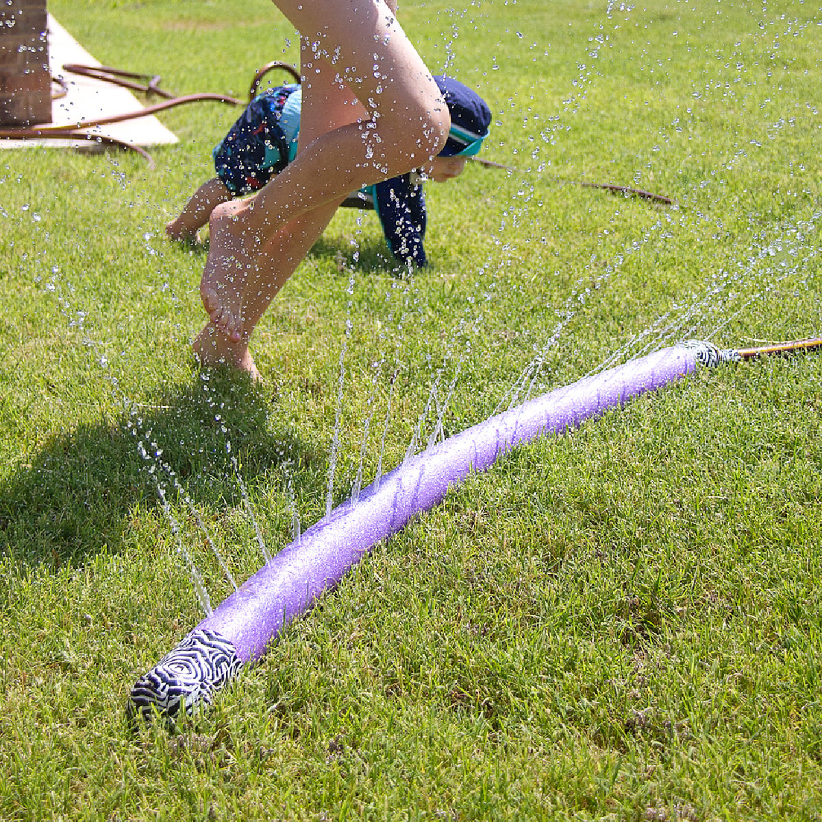 Pool Noodle Activities- purple sprinkler on grass with a kid- Kids Activities Blog