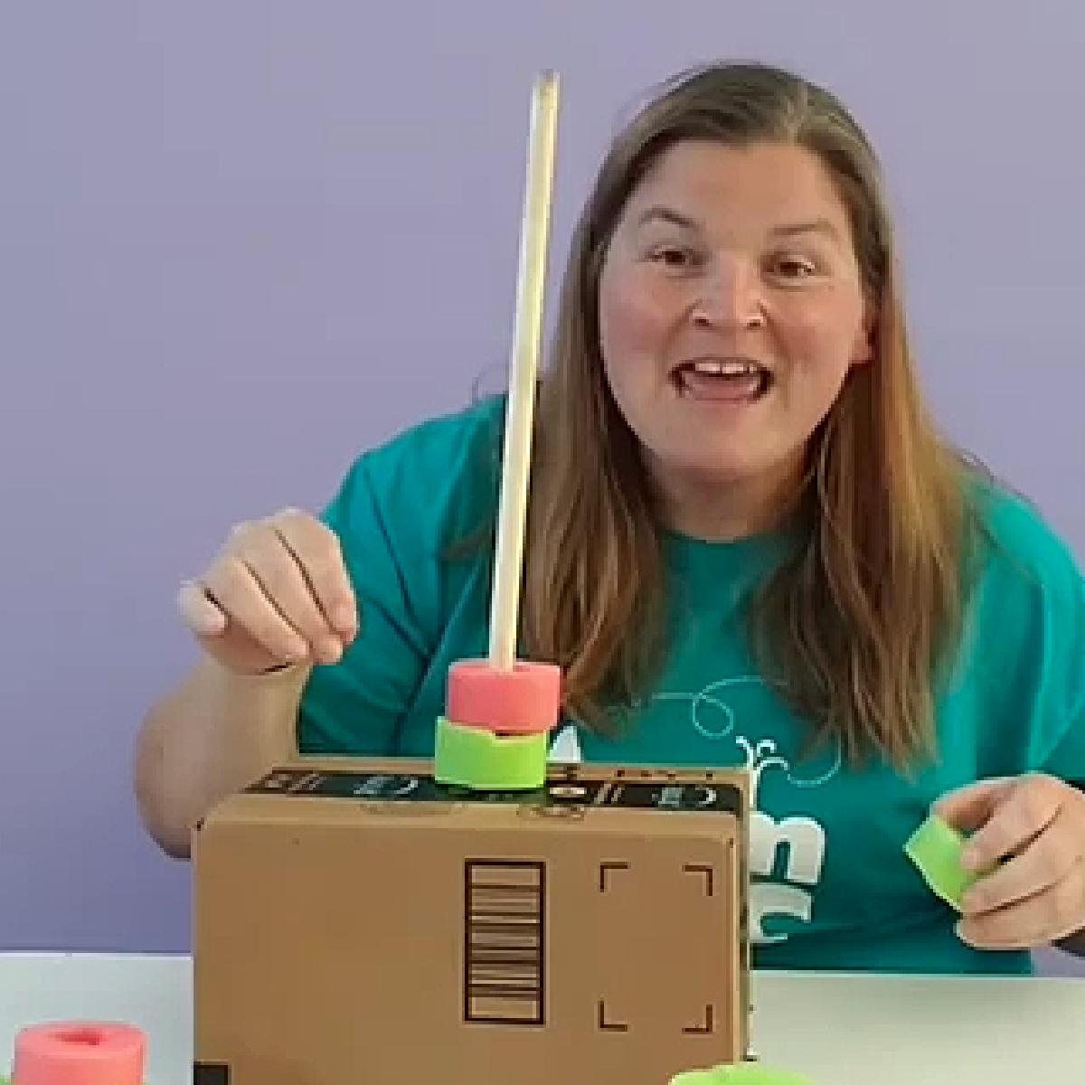 Pool Noodle Activities- Lady stacking noodle pieces on a dowel rod- Kids Activities Blog