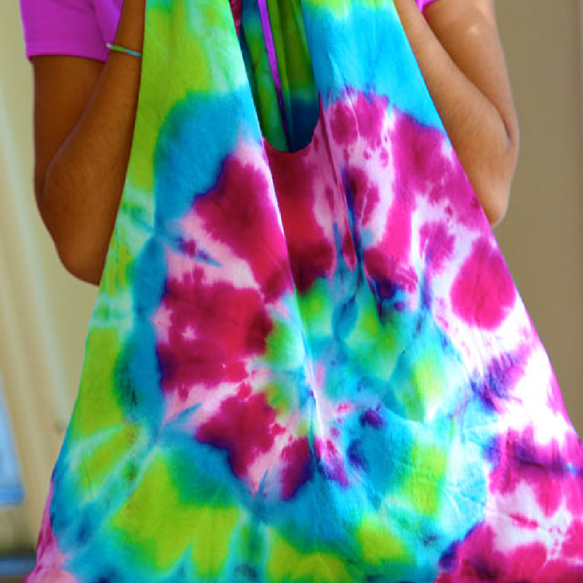 Tie Dye Craft- purple pink blue green tote bag held by girl - Kids activities Blog
