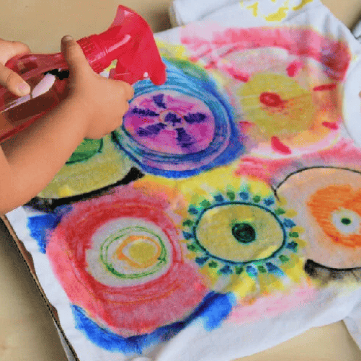 Tie Dye Craft- girl spraying tie dye with bottle - Kids activities Blog