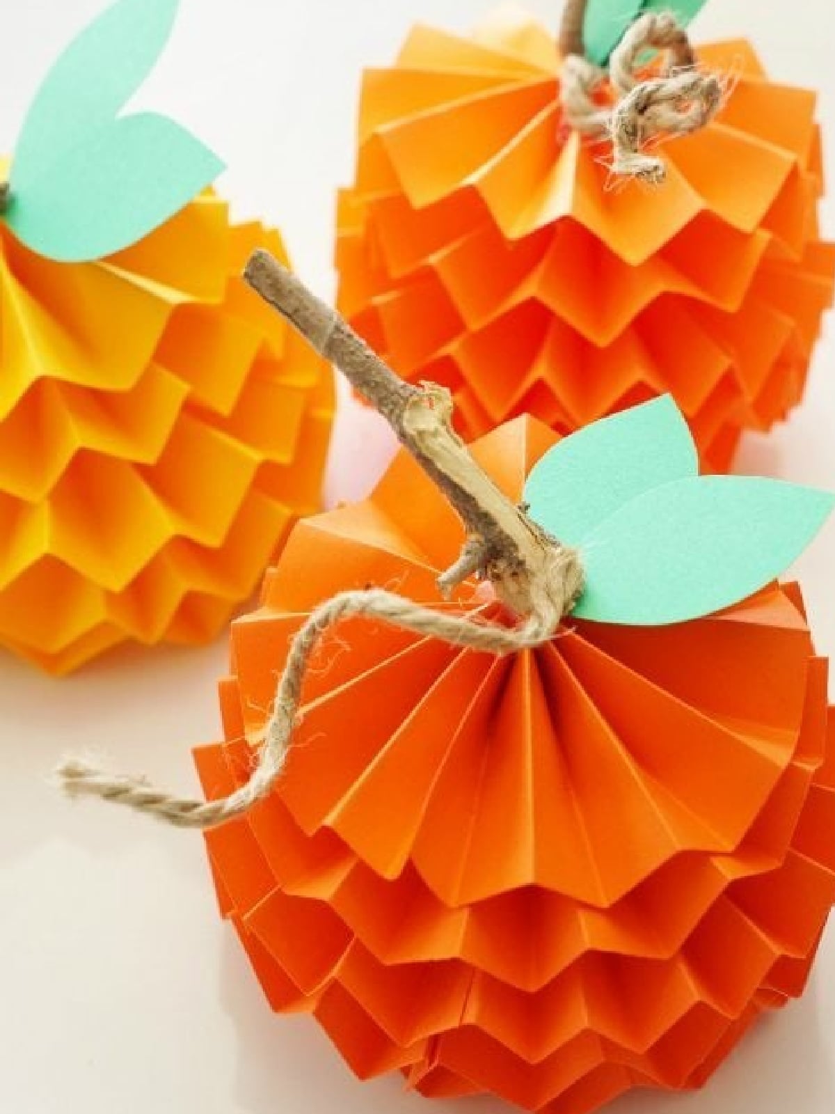 Pumpkin Activities- Crinkled paper pumpkin with stick, twine, and leaves- Kids Activities Blog