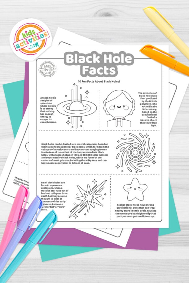 Black and white coloring pages with black hole facts lying on top of blue-green and purple sheets with assorted crayons on a dark grey background.
