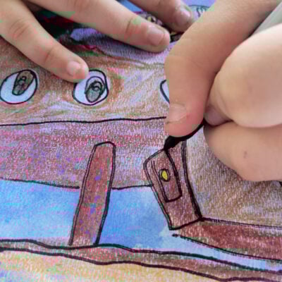 boy using a sharpie to trace outline of sunken ship - kids activities blog