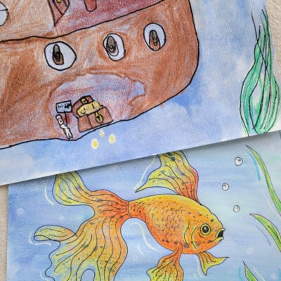 completed underwater scene wax resist art project featuring a sunken ship and goldfish - kids activities blog