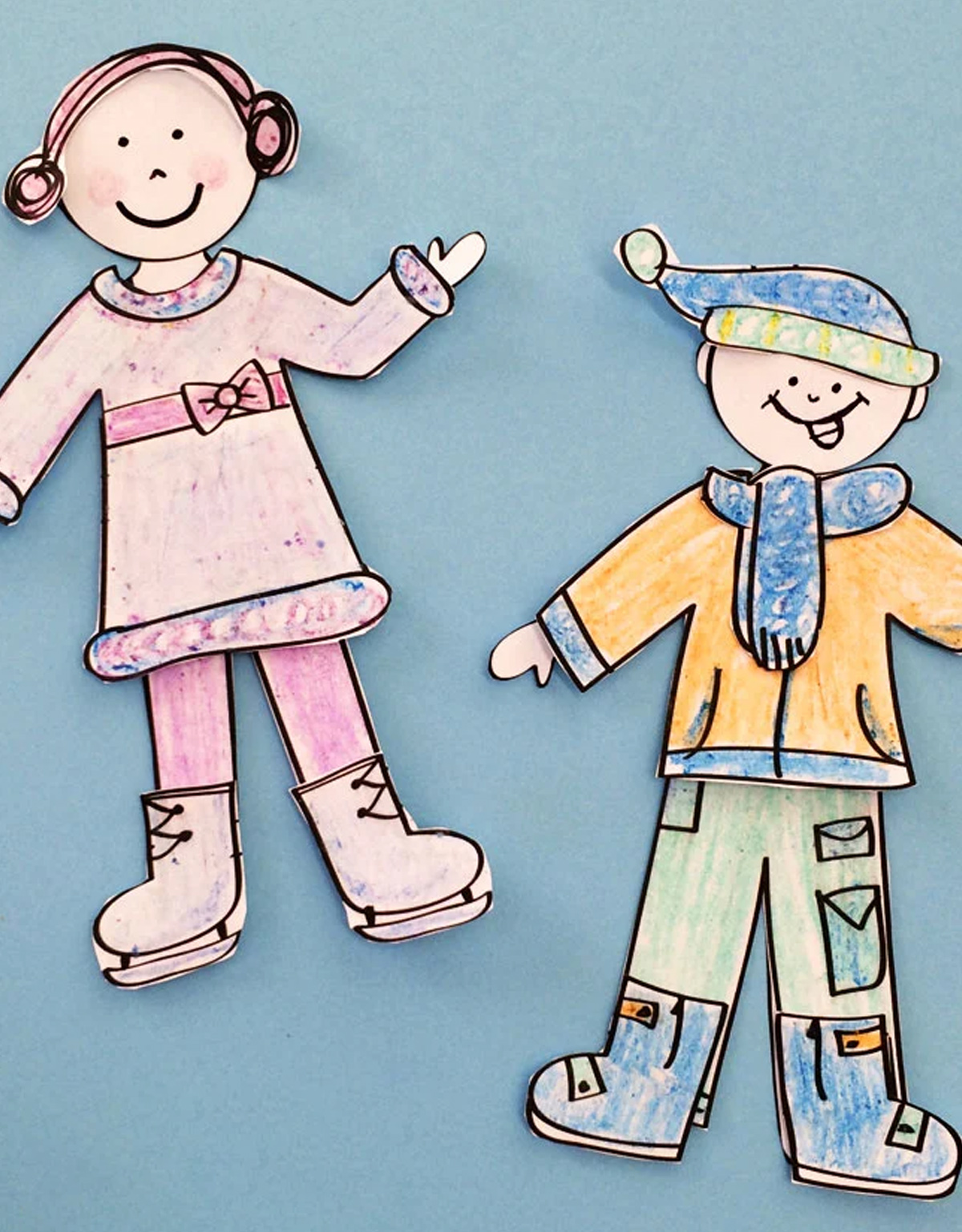 Two paper dolls made by kids and colored with coloring pencils.