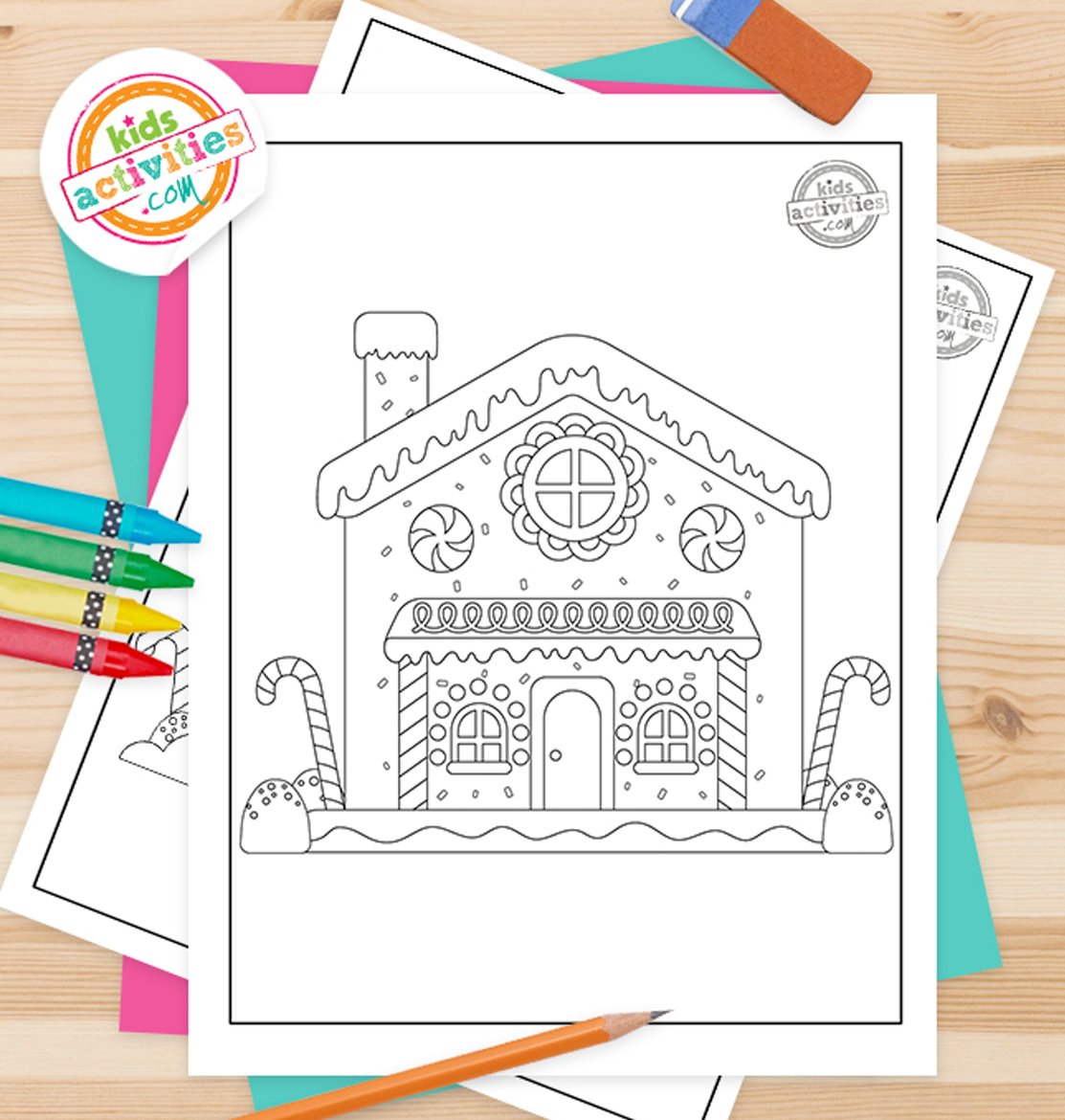 Stack of printed gingerbread house printables on top of green and purple pages, with markers next to them, on top of a brown background.