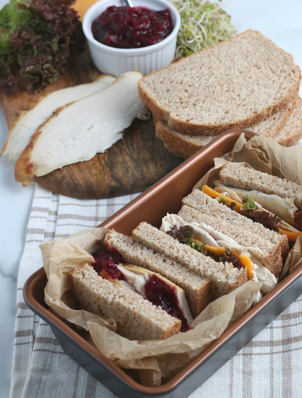 Mix of Turkey sandwiches on top of a gray table.