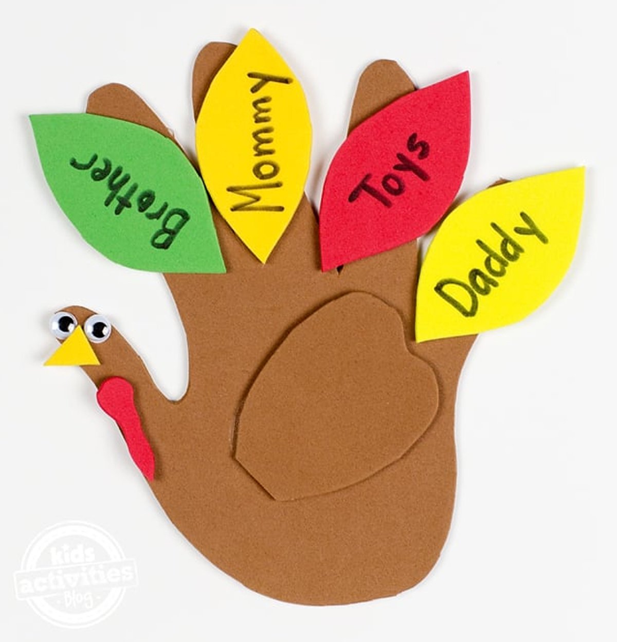 A turkey craft using a kids handprint with brown paper and other colorful leaves.