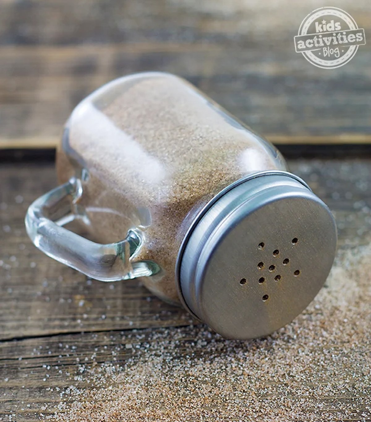 Image of a cinnamon-filled jar laying on a wooden table.