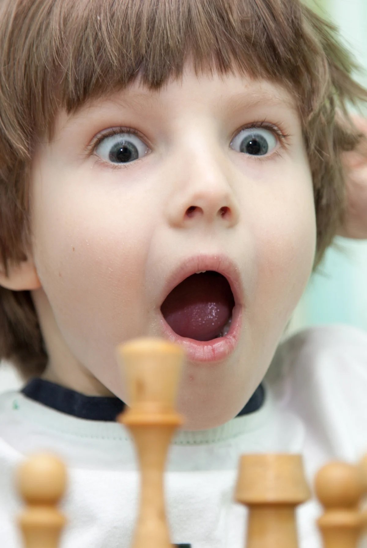 A picture of a young kid playing chess.
