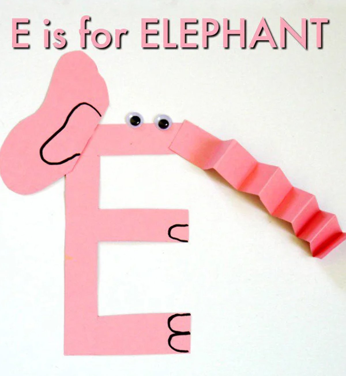 A colorful letter 'E' craft made from pink construction paper, decorated as an elephant placed on a white background.