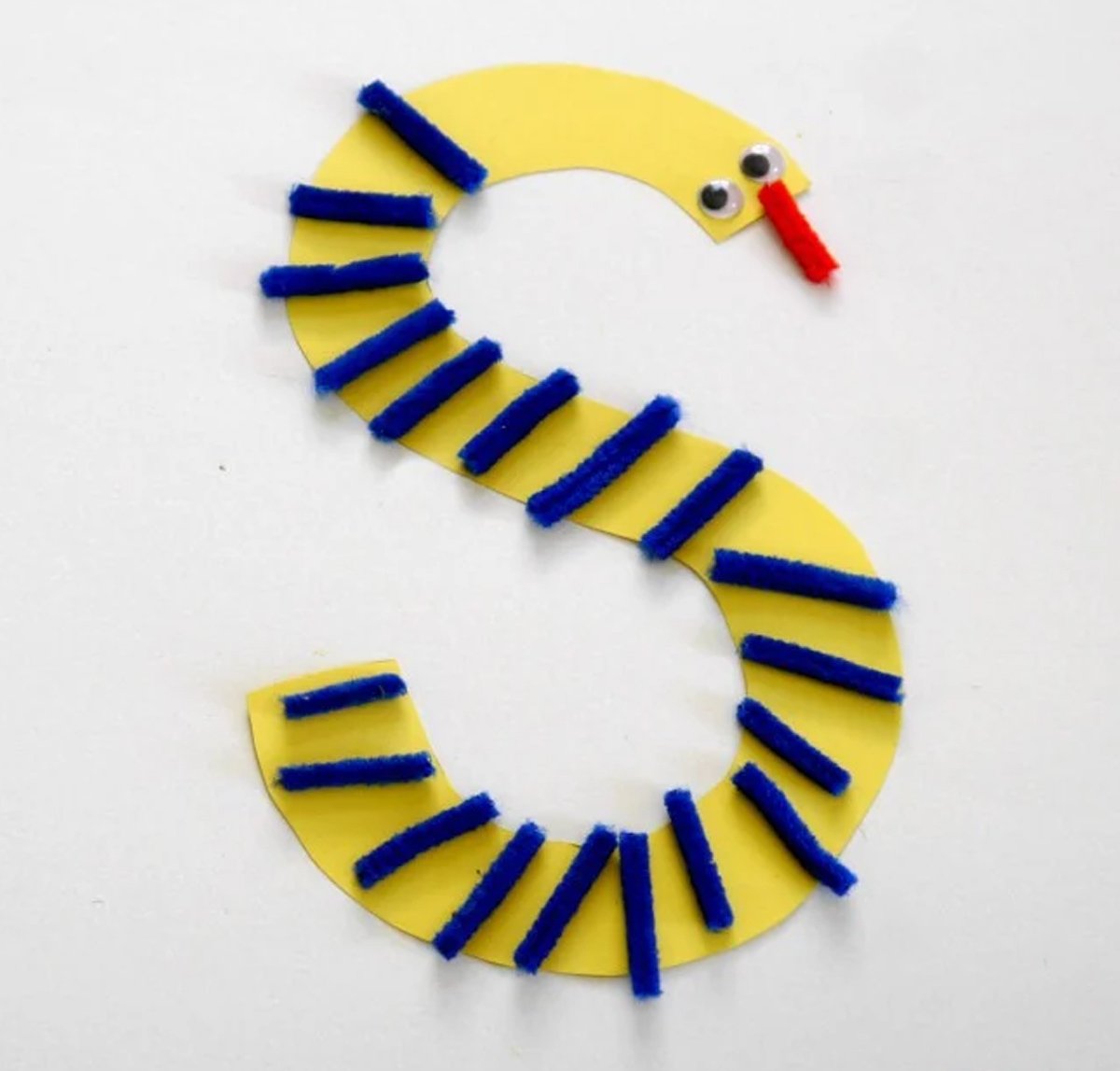 A snake-shaped S craft made with yellow construction paper and black paper.