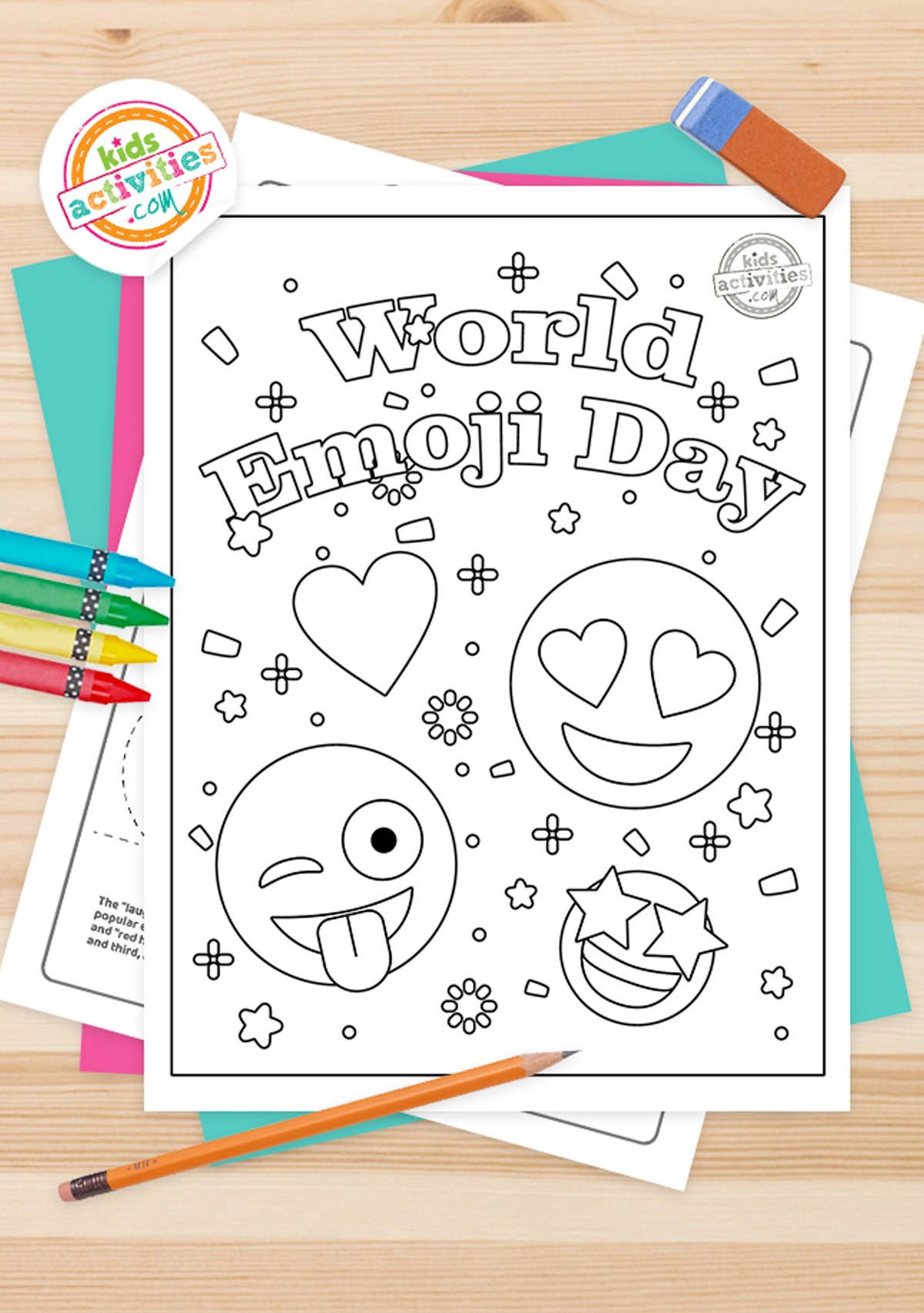 Black and white world emoji day coloring pages printables lying on top of blue-green and purple sheets with assorted magnetic letters on a brown background.