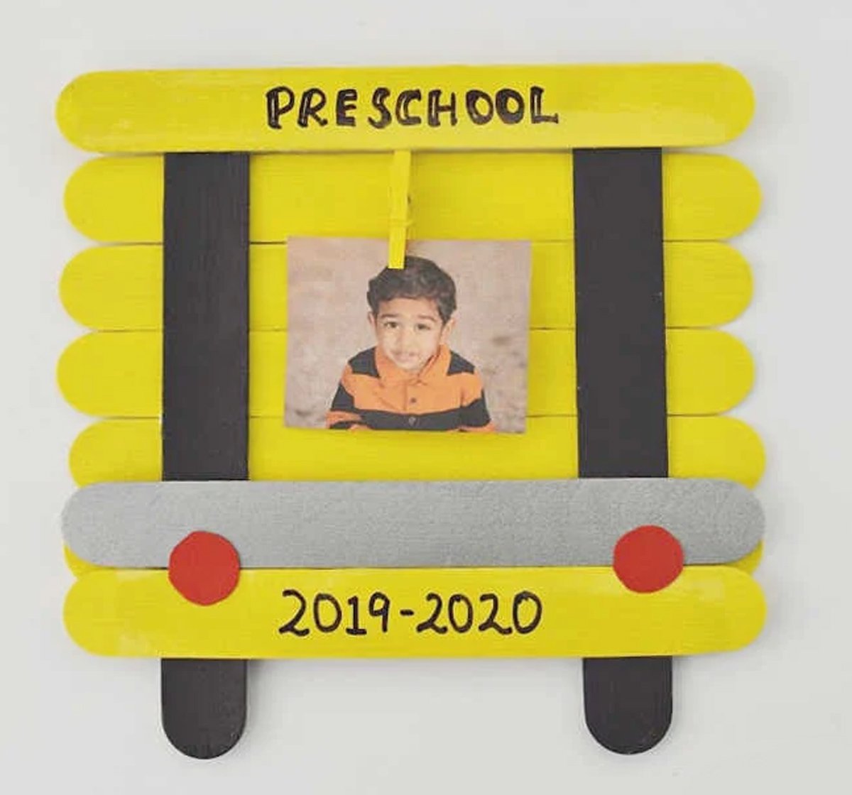 A yellow school bus frame with a kid's picture in the middle, and text that says 2019-2020.