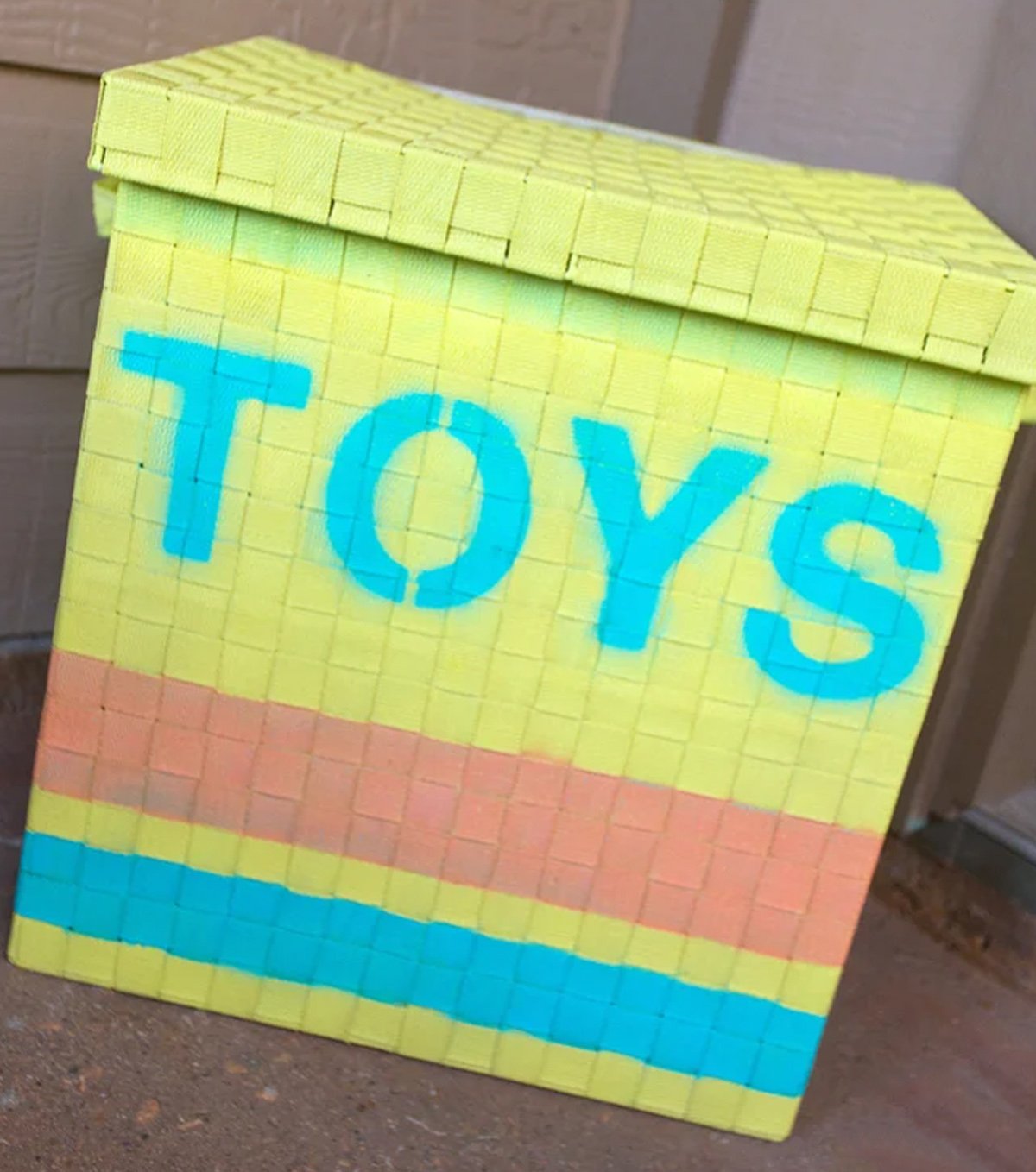 A homemade toys box in yellow, blue and orange. 