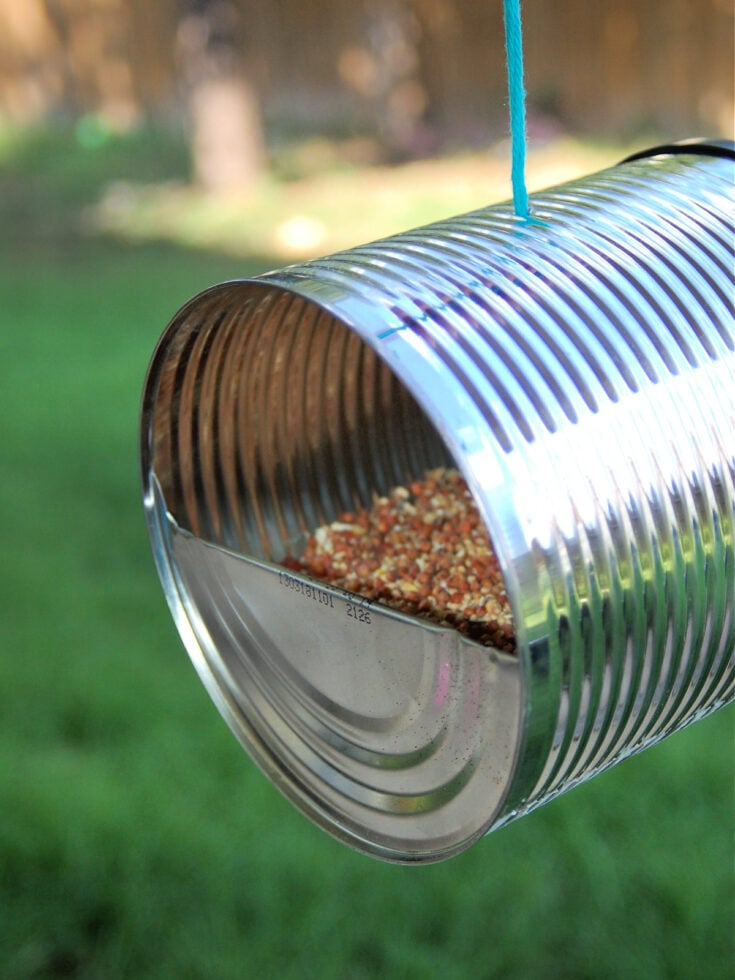 Bird Feeder Craft- finished- tin can with bird food in it outside- kids activities blog