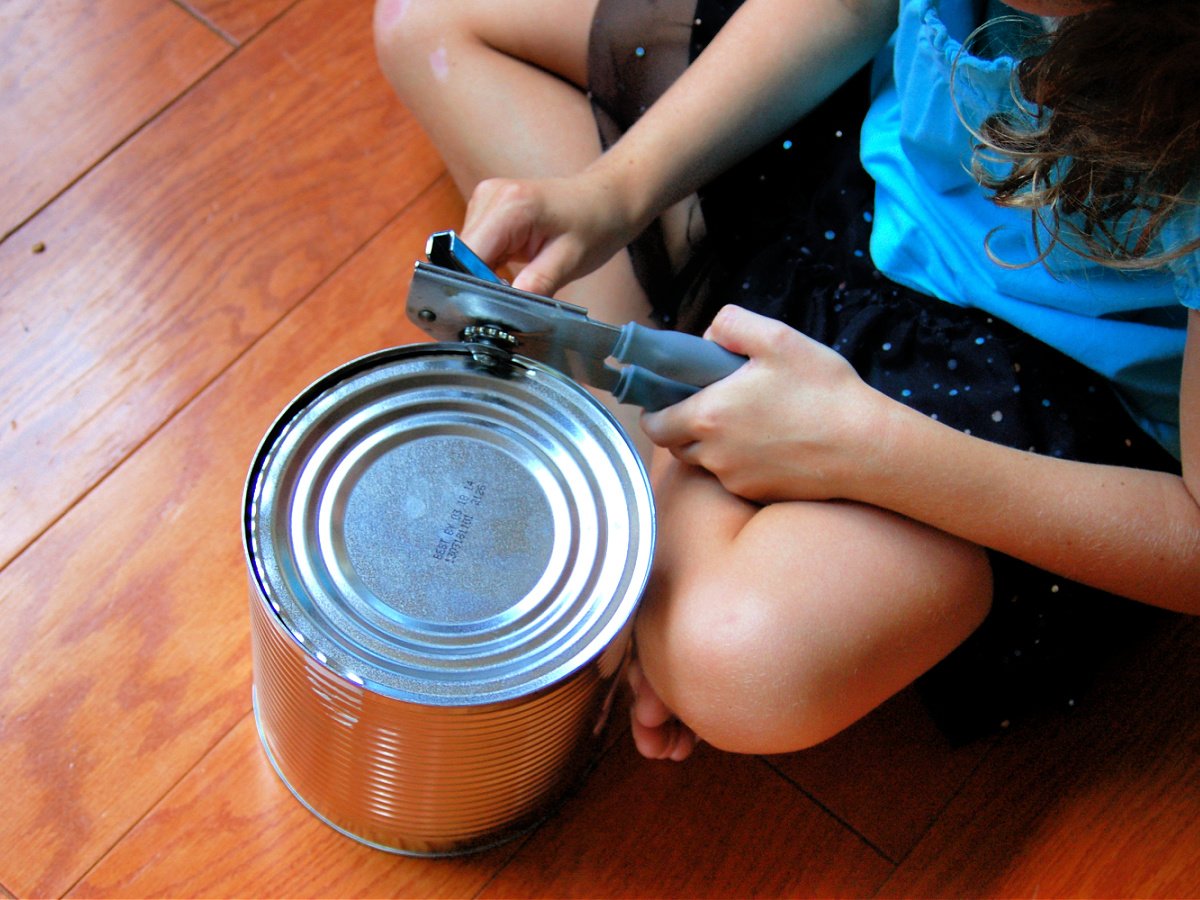 Bird Feeder Craft- child using can opener on tin can- kids activities blog