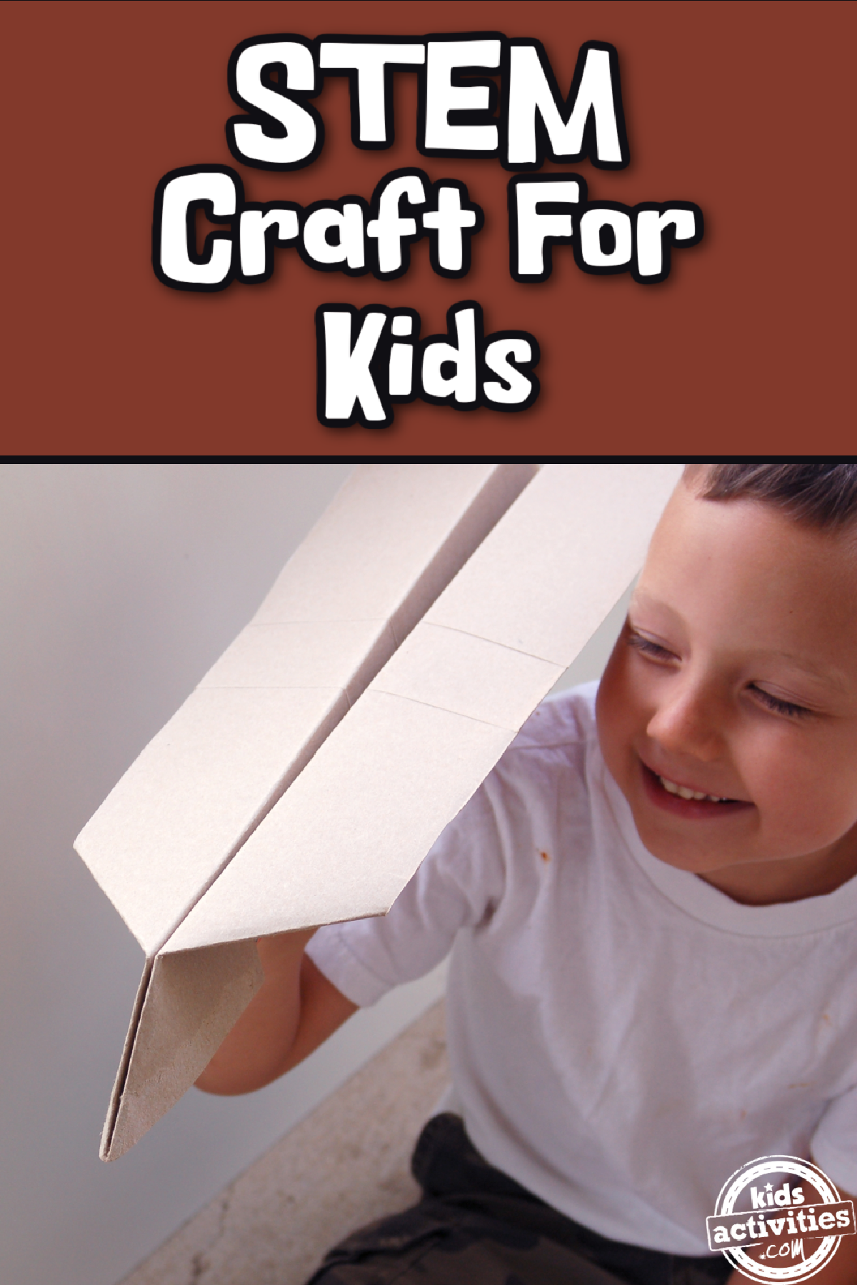 Giant Paper Airplane- Boy holding a white paper air plane in a white shirt- kids activities blog