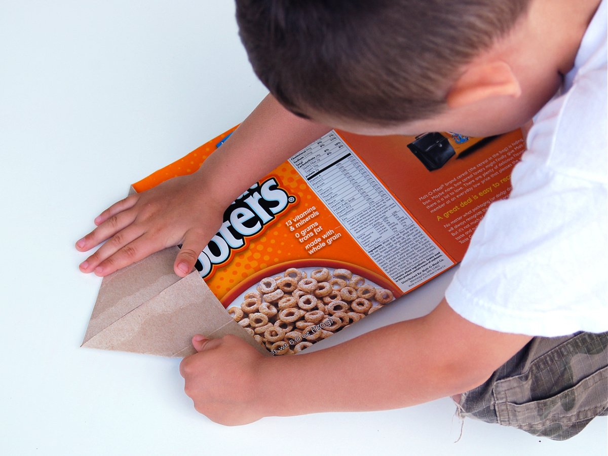 Giant Paper Airplane- Step 2- Fold over the flaps by a little boy- Kids Activities Blog