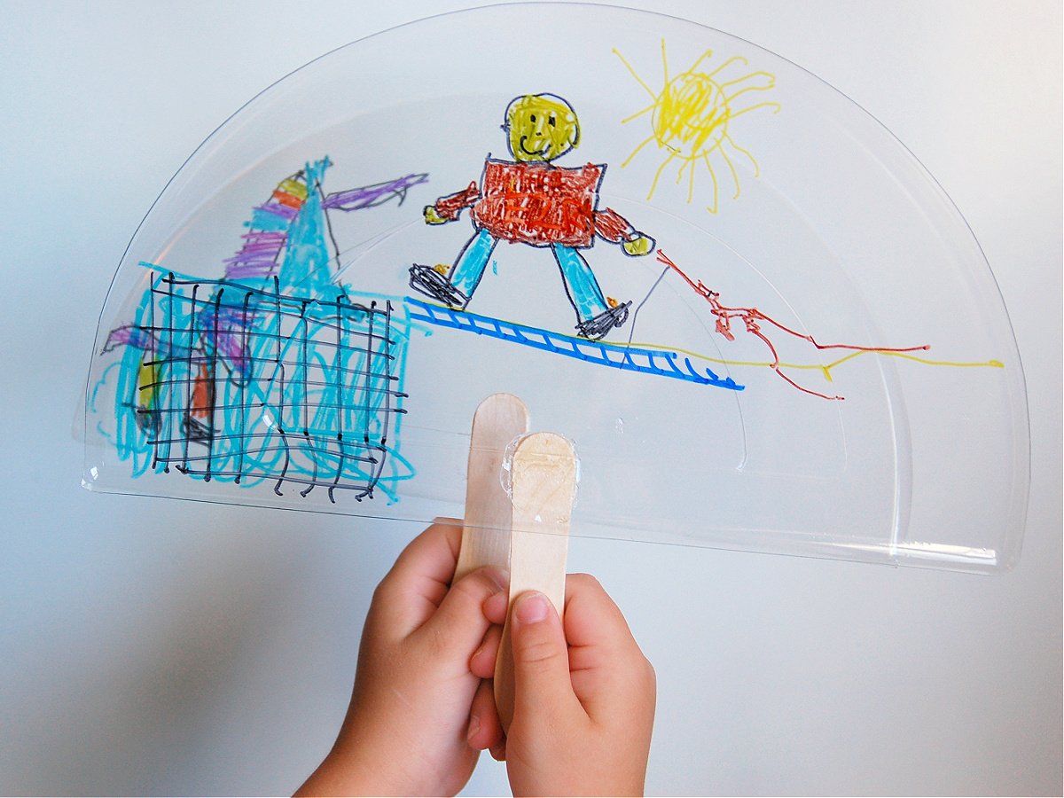 Layered Art- Step 3- Glue popsicle sticks onto the plastic lids with pictures on them- kids activities blog