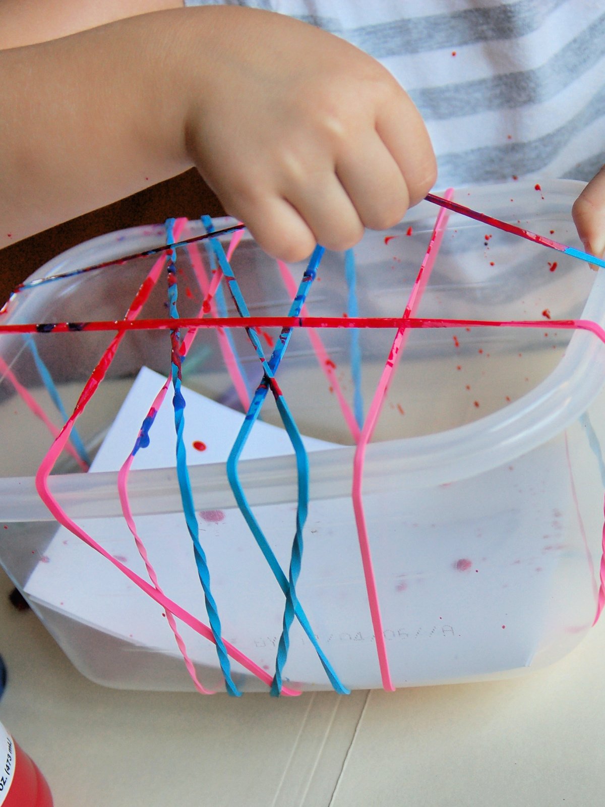 Splatter Paint- Step 2- Pull the rubber bands up and let the paint splatter- kids activities blog