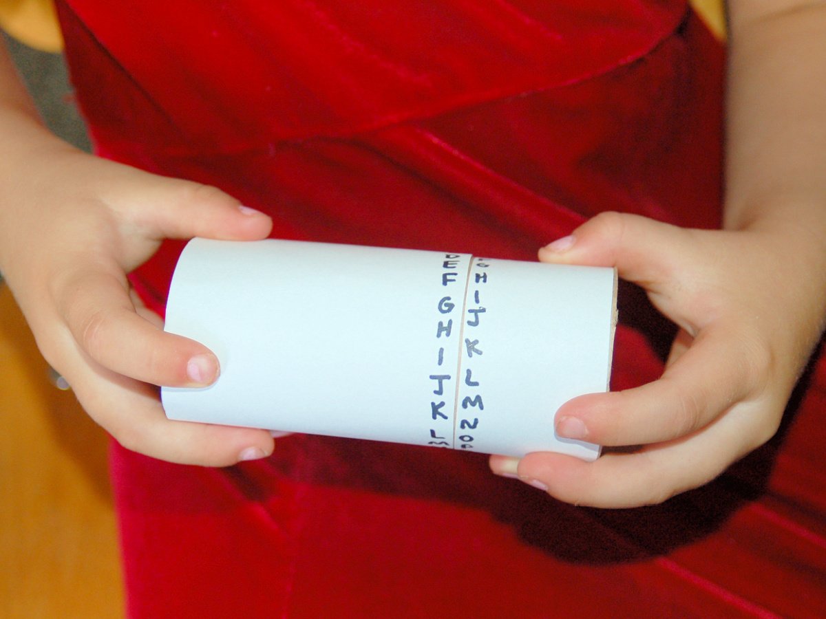 Coded Message Craft- Child holding decoder- kids activities blog