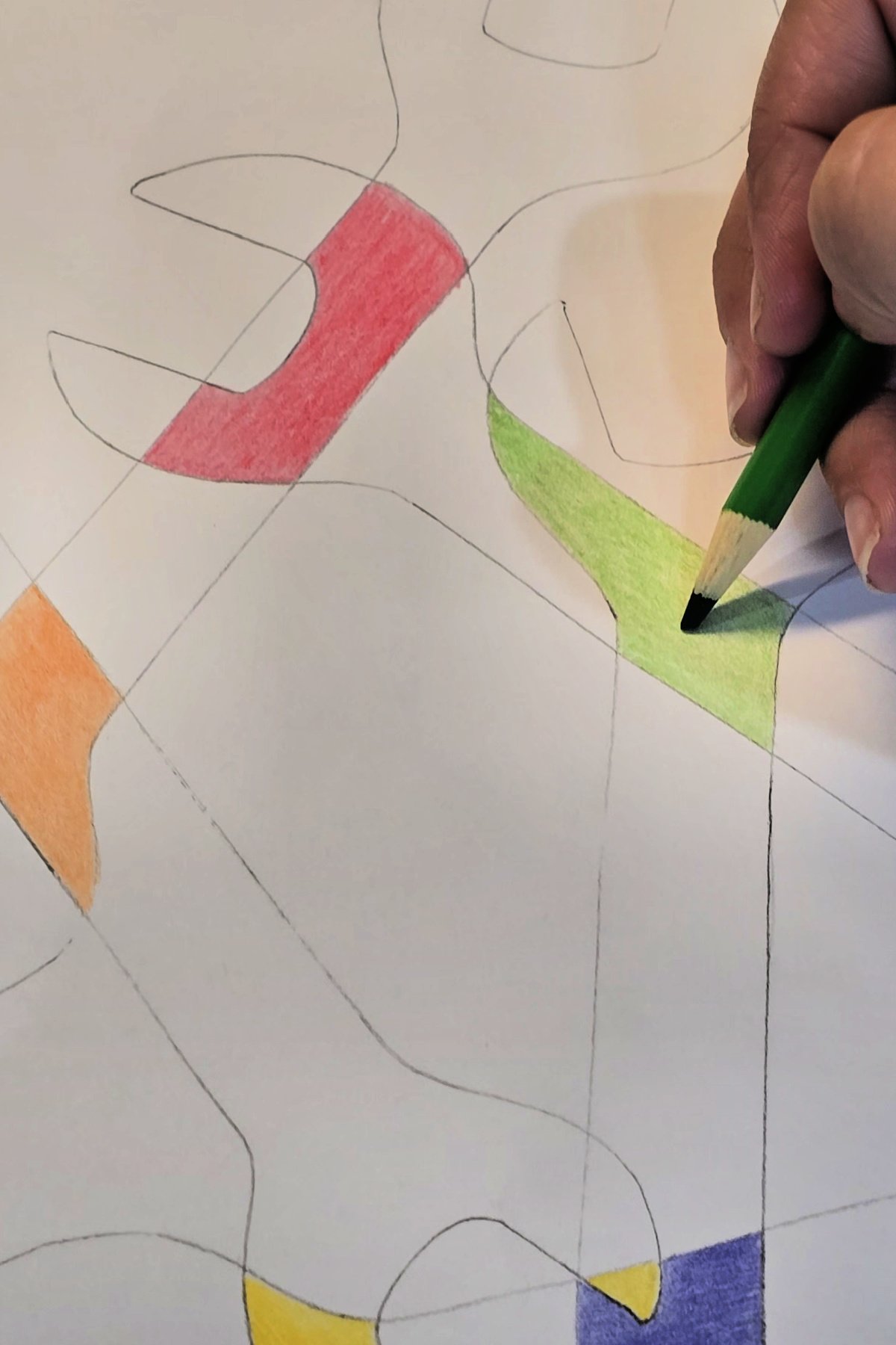 step 3 - using a colored pencil to color sections of drawing where wrench shapes overlap - kids activities blog