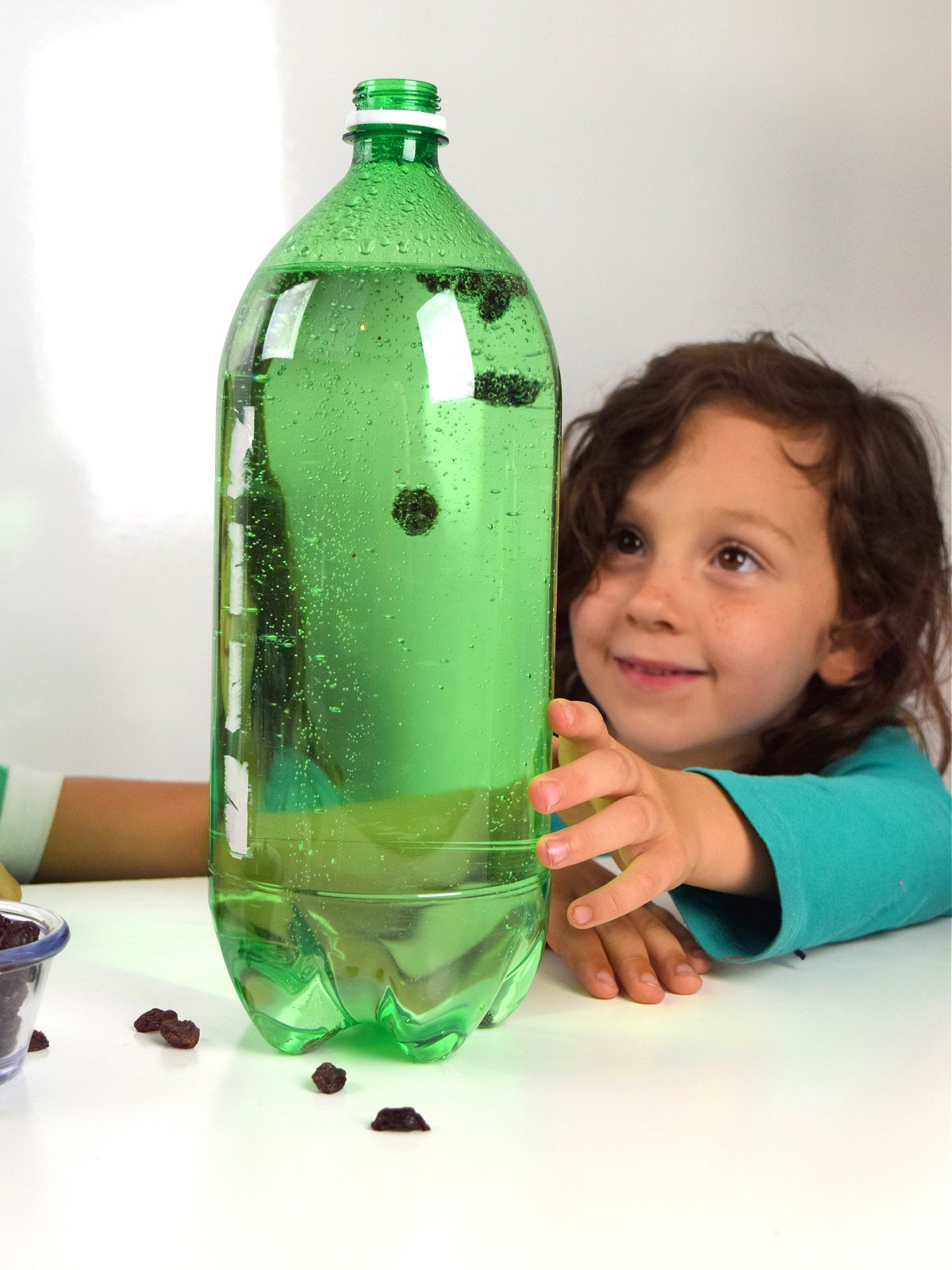 Dancing Raisins- Step 4 - Little girl watching raisins in bottle - Kids Activities Blog