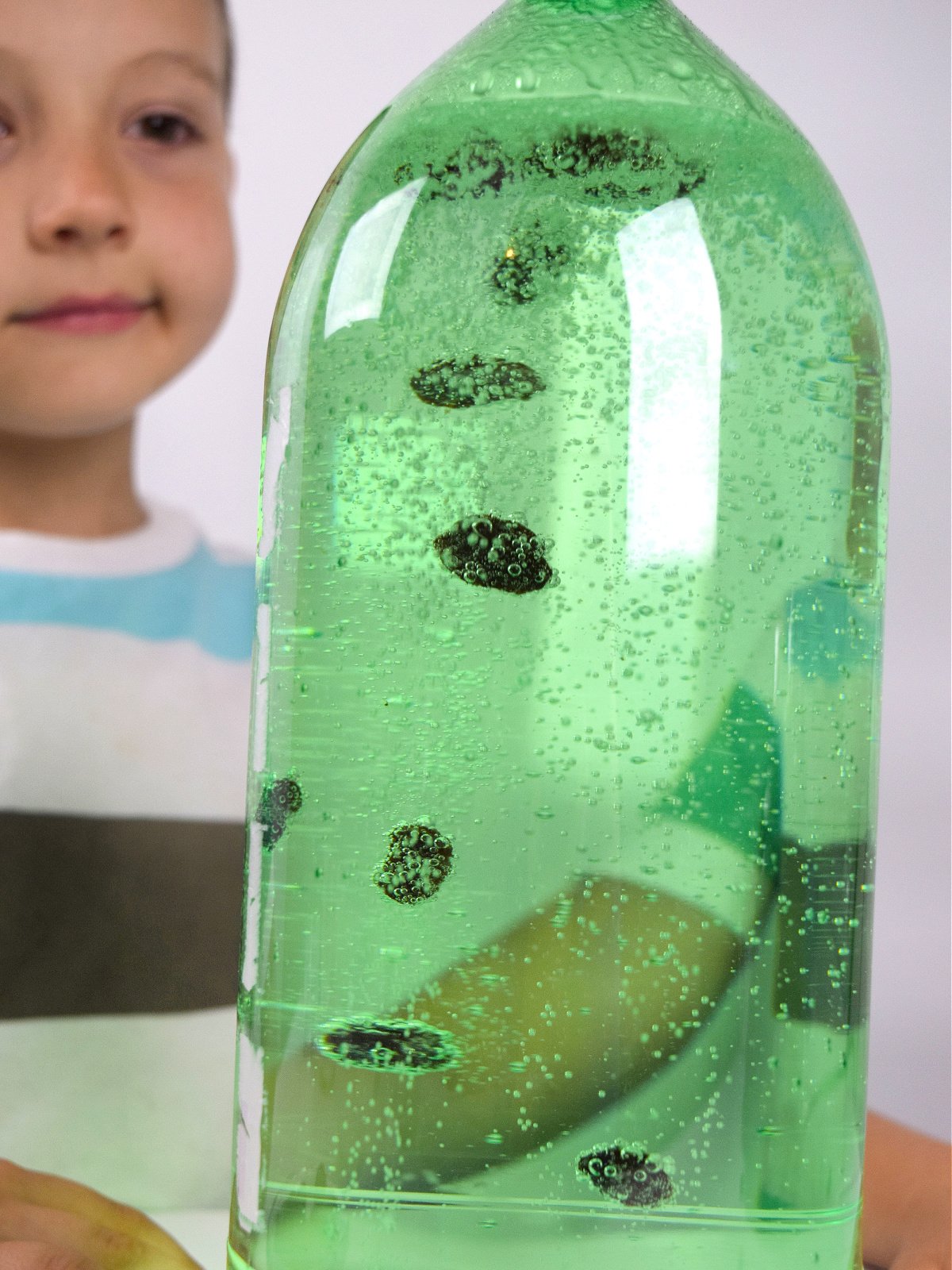 Dancing Raisins- Finished- Boy watching raisins sink and float in bottle- kids activities blog