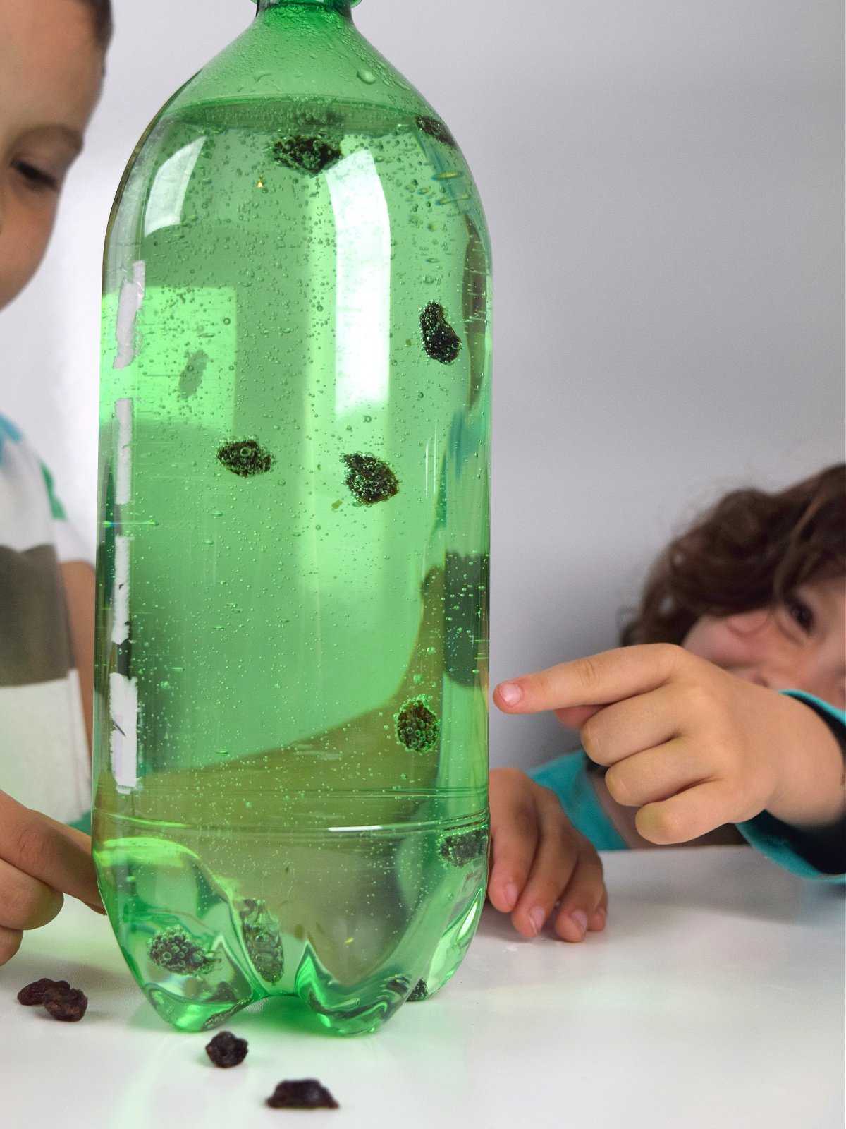 Dancing Raisins- little boy and girl watching raisins in green bottle- kids activities blog