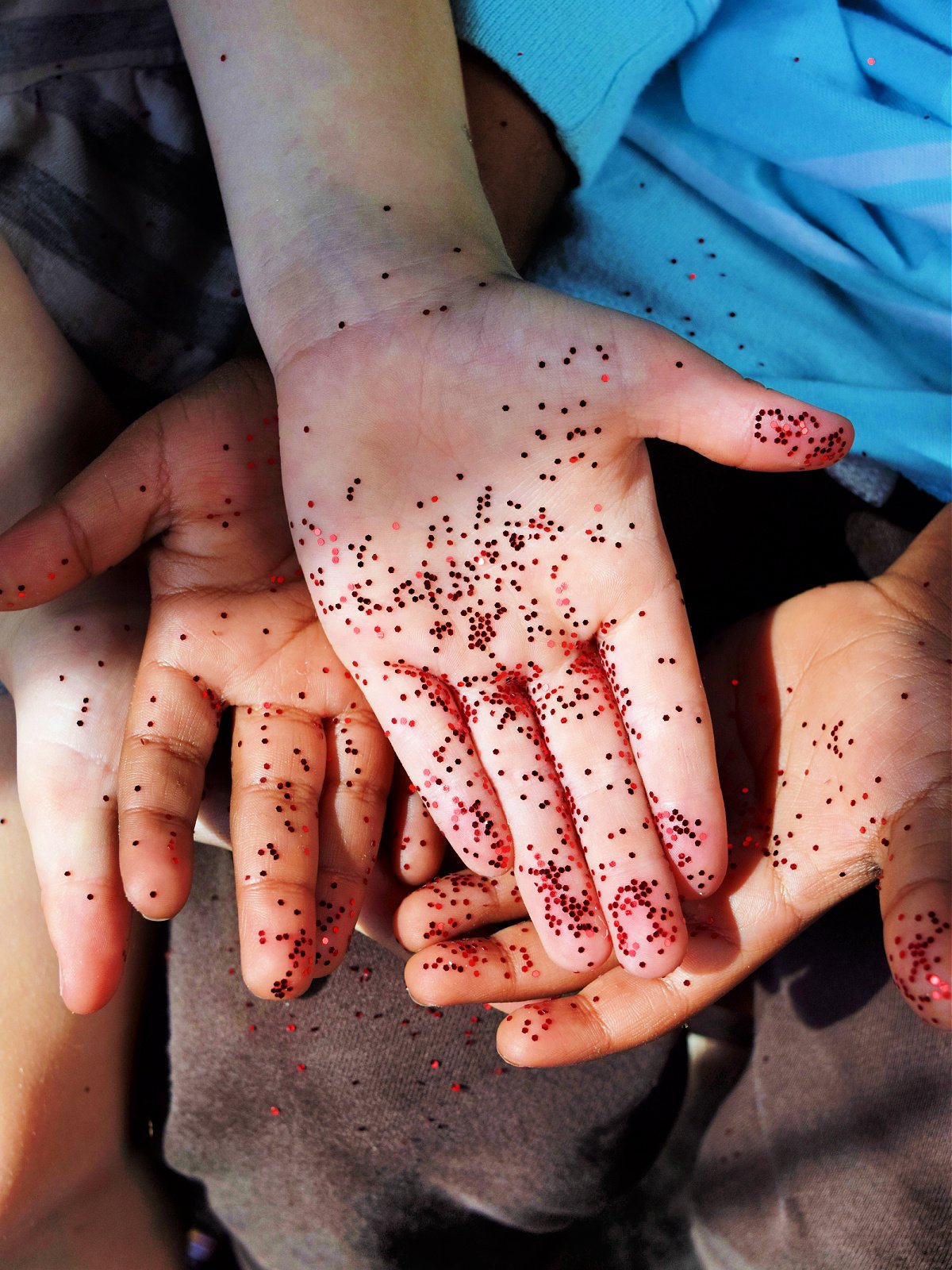 How Germs Spread- Finished- hands laying on top of hands with glitter- kids activities blog
