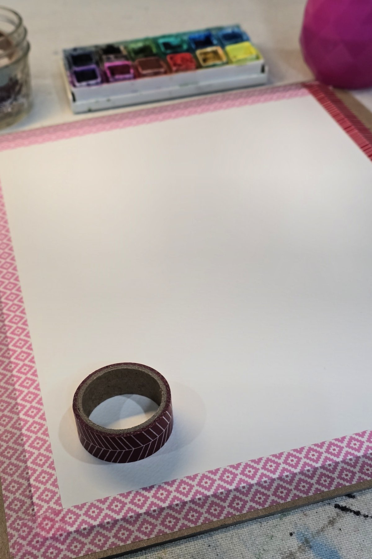 step 1 - using washi tape to tape watercolor paper to a piece of cardboard - kids activities blog