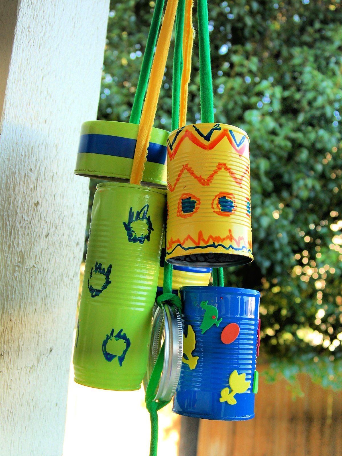Homemade wind chimes craft- finished- colorful windchimes hanging from a tree- kids activities blog