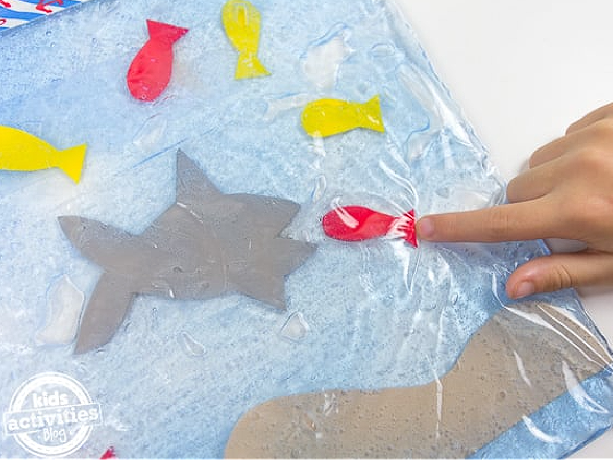 Shark Sensory Bag- Light blue bag with a shark ad red and yellow fish- kids activities blog