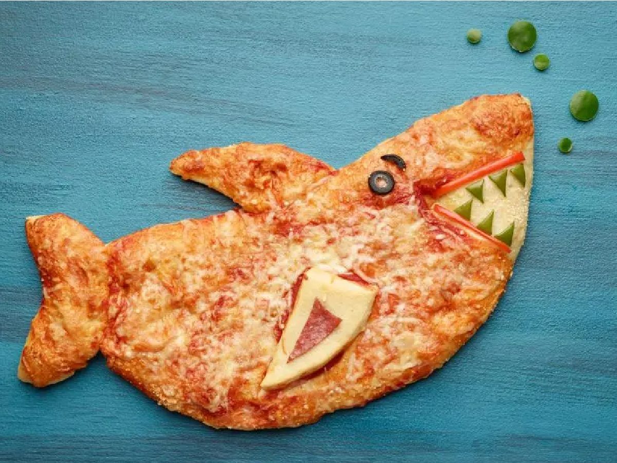 Shark Week- Pizza that is shaped like a shark against a blue background- kids activities blog