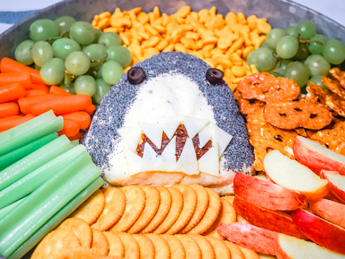 Shark Week- Charcuterie board with crackers, veggies, pretzel, and shark cheese ball- kids activities blog