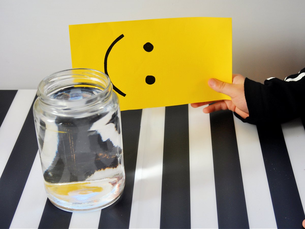 Water Illusion- Step 1- Draw a smiley face on paper and get ready to place it behind water- kids activities blog