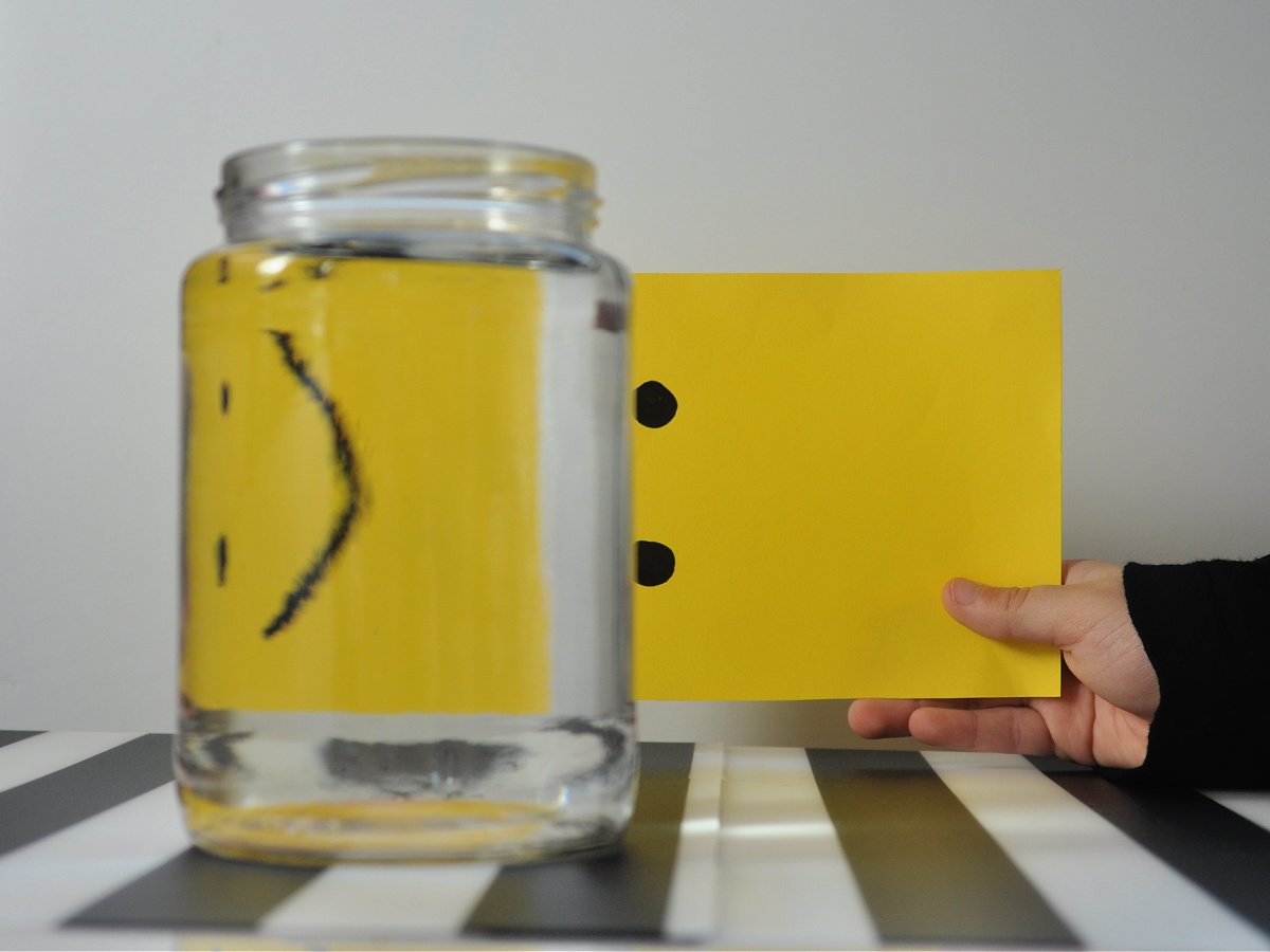 Water illusion- step 2- Paper behind water with a frown instead of a smile- kids activities blog