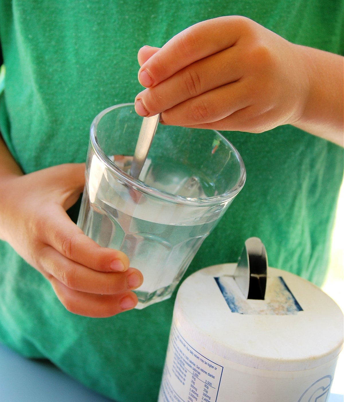 Growing Gummies- Step 2- mixing salt in a glass with a spoon- kids activities blog
