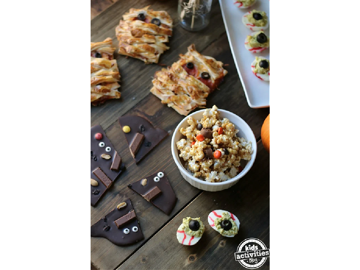 Halloween Recipes- Sweets and savory finger foods on a wooden table Halloween themed -Kids Activities Blog