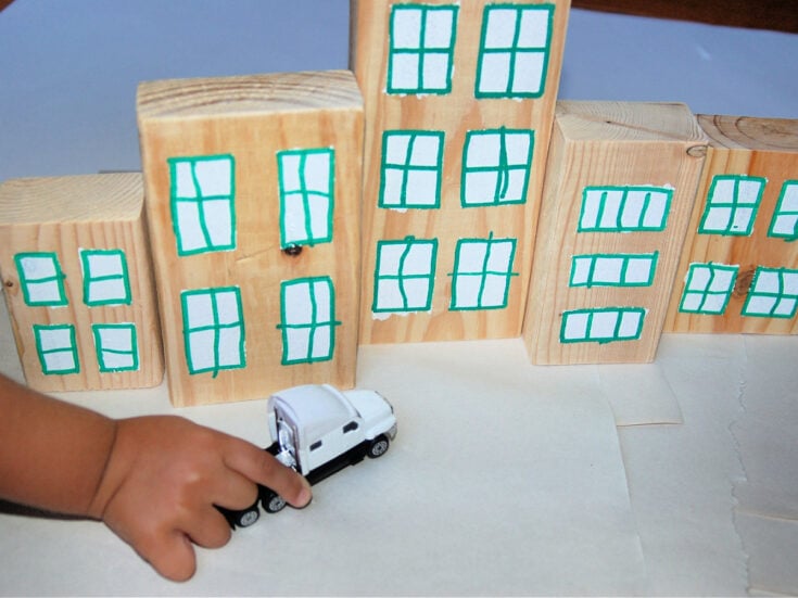 Wooden Town Blocks- Step 6- Set up town and little hand pushes car in front - Kids Activities Blog