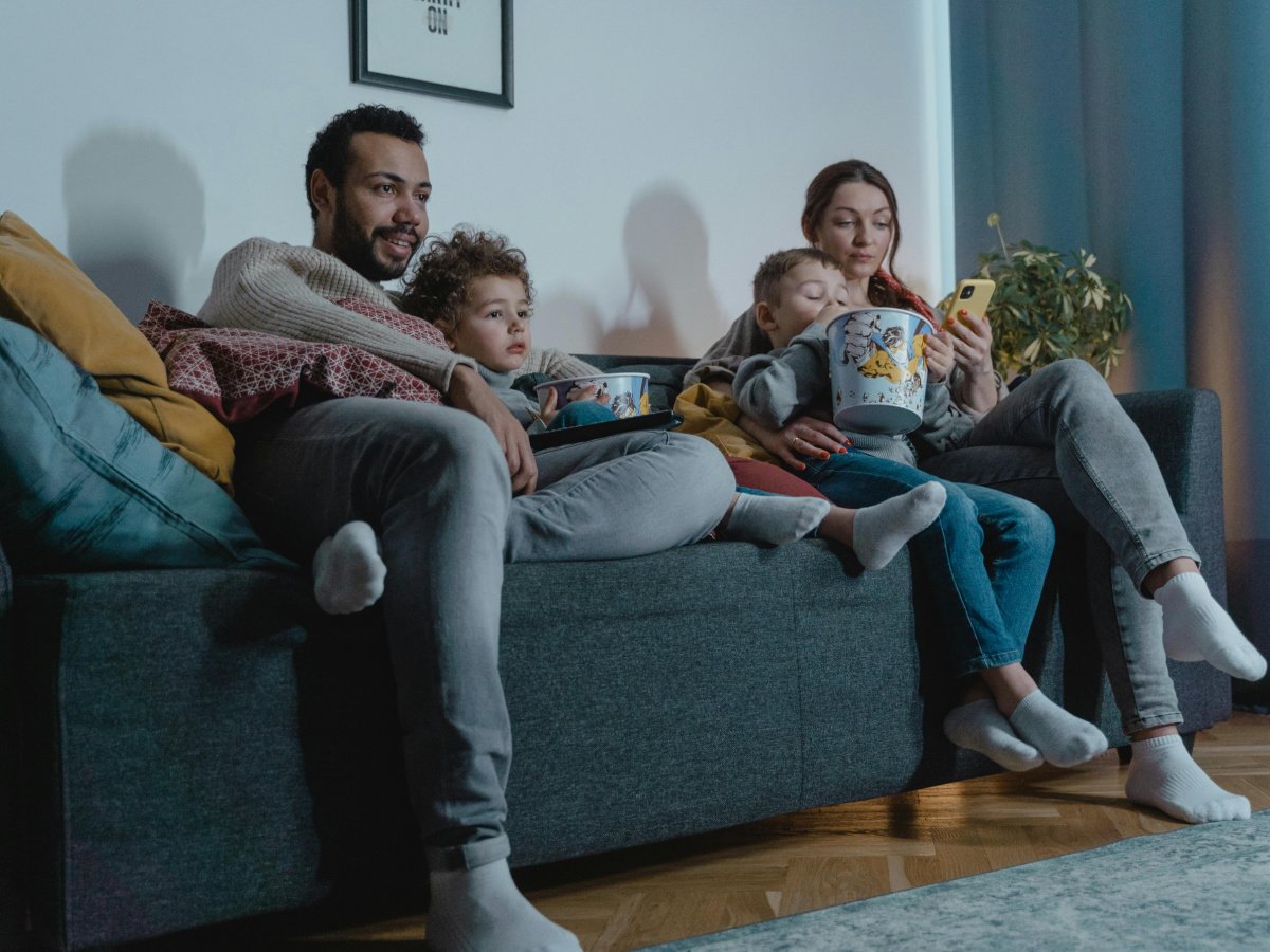 Halloween Alternative ideas- family sitting on couch with popcorn watching movies- kids activities blog