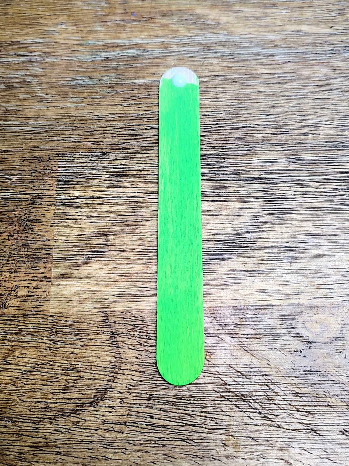 Veterans Day Poppy Craft- Step 10- Add a dot of glue to top of green popsicle stick- Kids Activities Blog