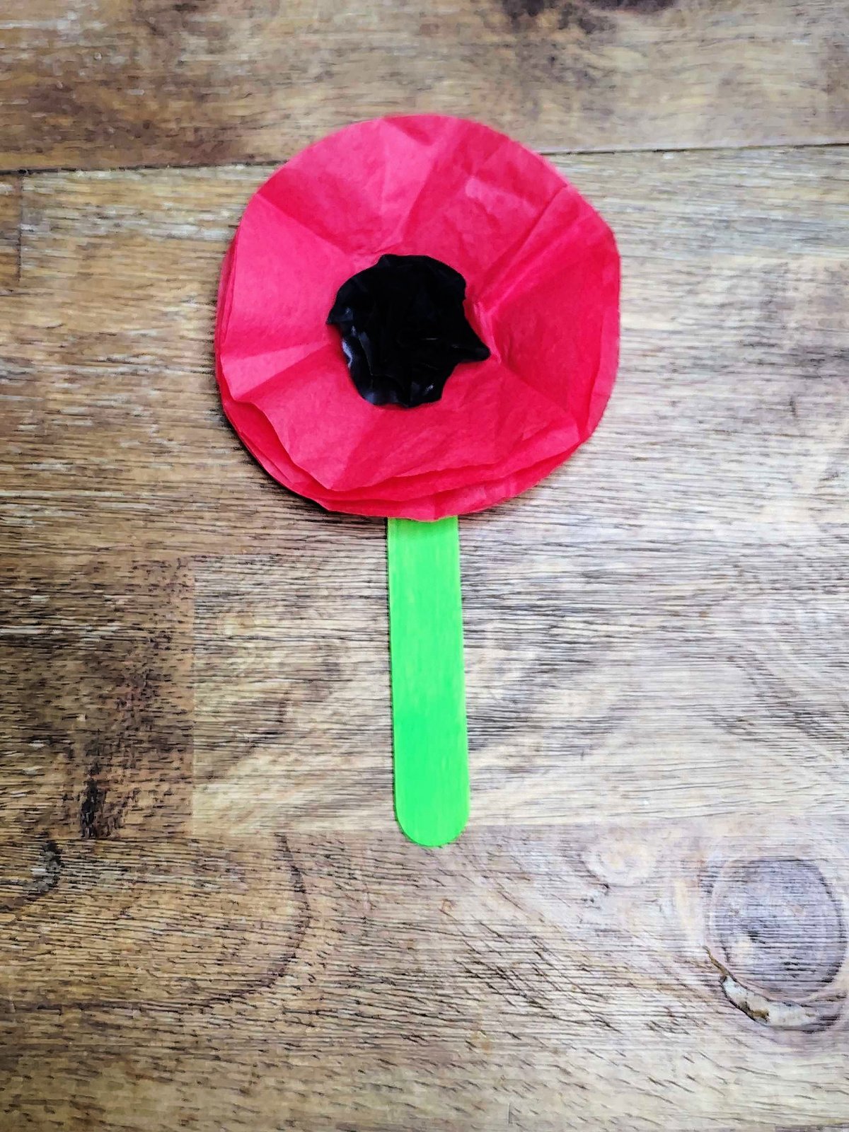 Veterans Day Poppy Craft- Step 11- Completed tissue paper and popsicle stick poppy- Kids Activities Blog